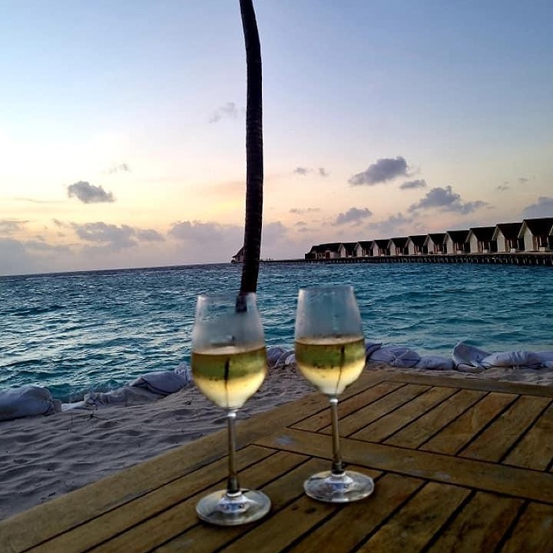 Two glasses of white wine in front of the beach and ocean